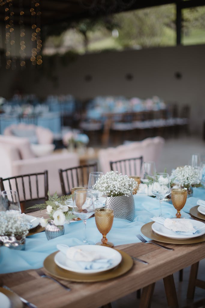 Beautifully decorated outdoor wedding table with flowers and elegant tableware.